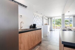 A modern kitchen with a wooden countertop, a coffee machine, and a sink. - Oceanfront 2BR Condo • One Mambo 5 by Bocobay (Willemstad)