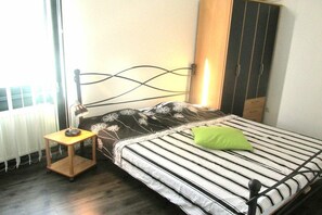 Ein Schlafzimmer mit einem Bett, einem Nachttisch, einer Lampe und einem Kleiderschrank.