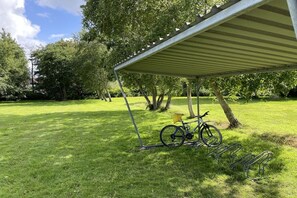 Ein überdachter Außenbereich mit einem Fahrradständer und einem Fahrrad.