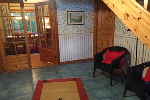 A room with a wooden floor, a patterned wall, a framed picture, and a red and beige rug. - Holiday home in Eschede with swimming pool (Eschede)