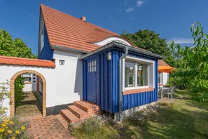 A house with a red tiled roof, a blue exterior, and a brick entrance. - The Beautiful House in Sellin—Pure Relaxation with a Sauna and Fireplace (Sellin)