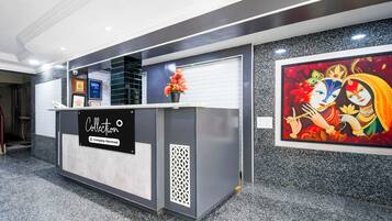 Uma receção com placa 'Collection', certificados emoldurados e um arranjo floral.
