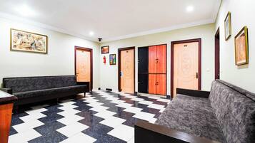 Um hall com piso quadriculado, dois sofás e um balcão de recepção.