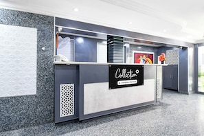 A reception desk with a sign that reads 'Collection Company-Serviced'. - Collection O Railway Station (Raipur)