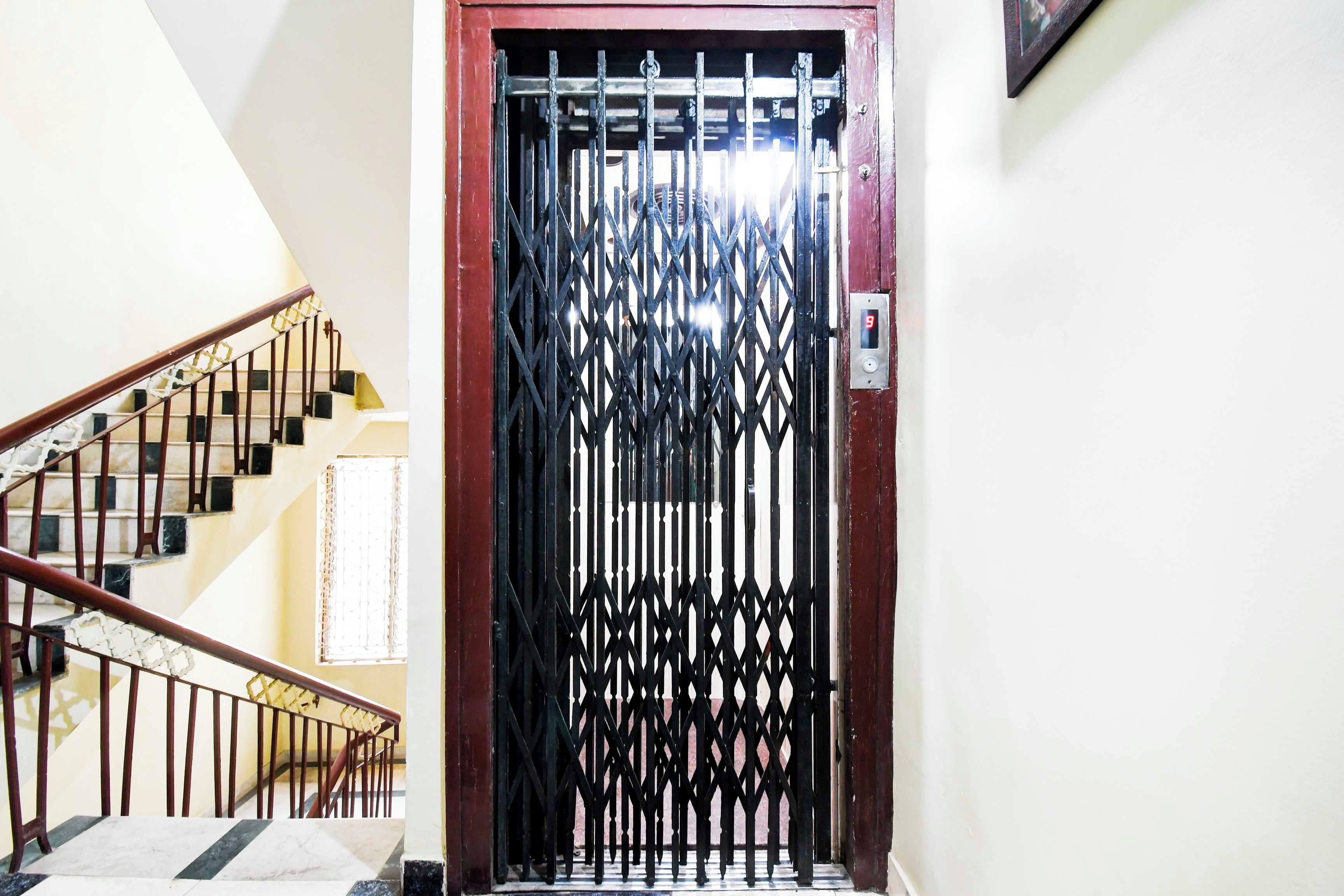 Escada com portão de metal no topo, dando acesso a um quarto.