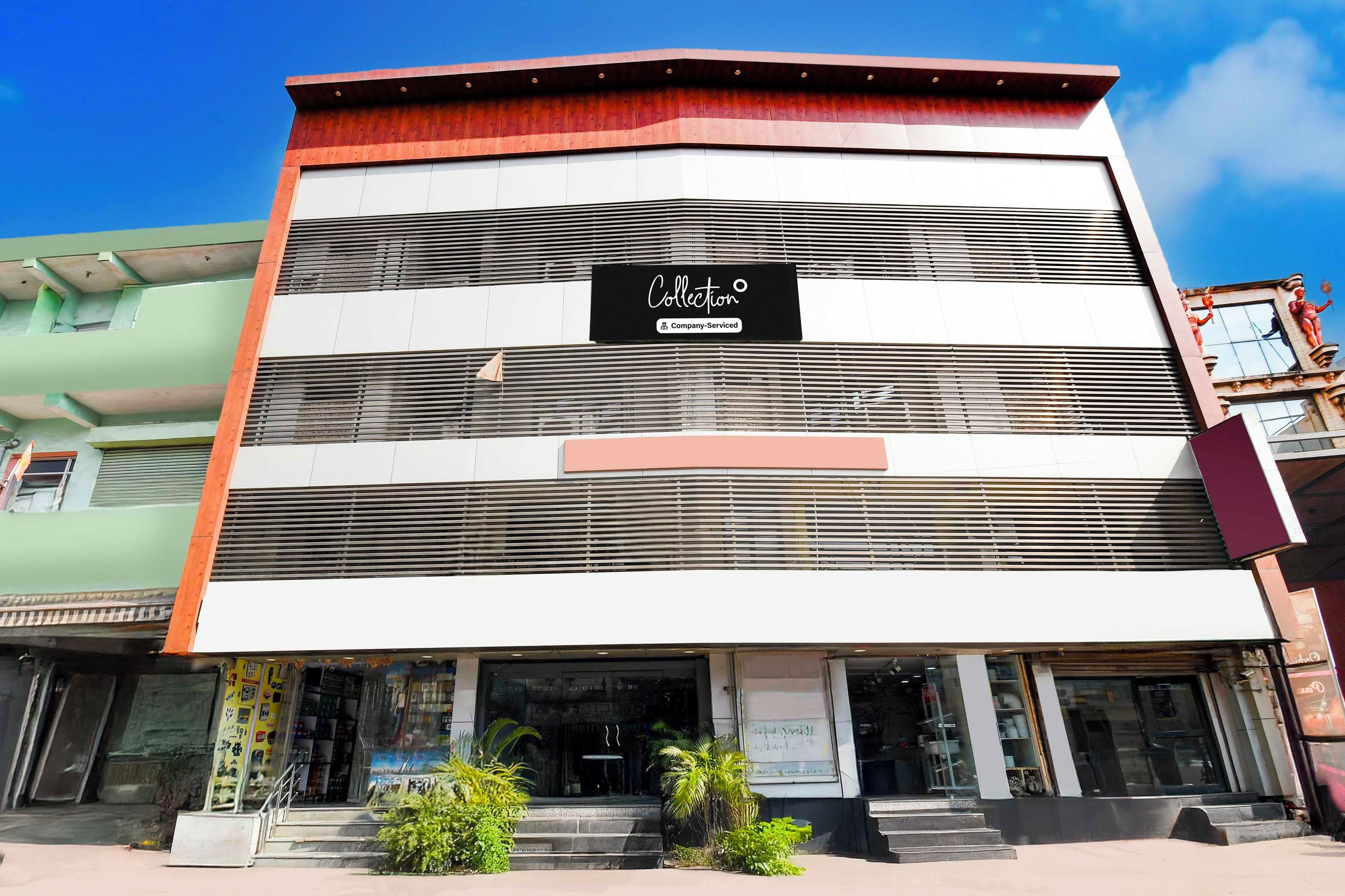 Um edifício de vários andares com uma placa indicando serviço de recolha.