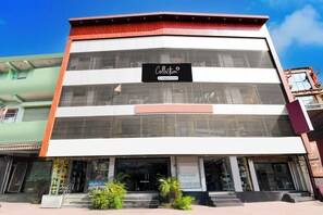 Um edifício de vários andares com uma placa indicando serviço de recolha.
