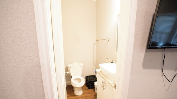 Une salle de bain avec des toilettes, un lavabo et un miroir.