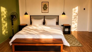 A neatly made bed with a wooden headboard, two bedside tables with lamps, a patterned rug, and a wall-mounted picture. - Tranquil hotel in enchanting Ella perfect for relaxing stay. (Ella)