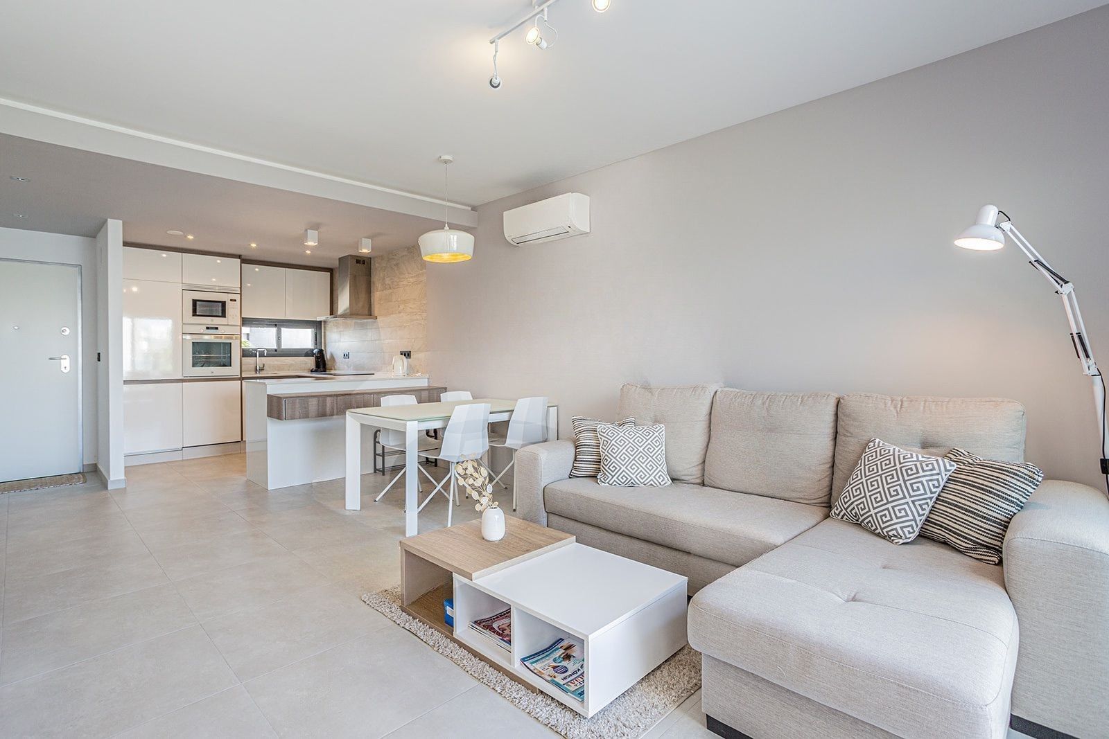 A modern living space with a sofa, coffee table, and dining area.