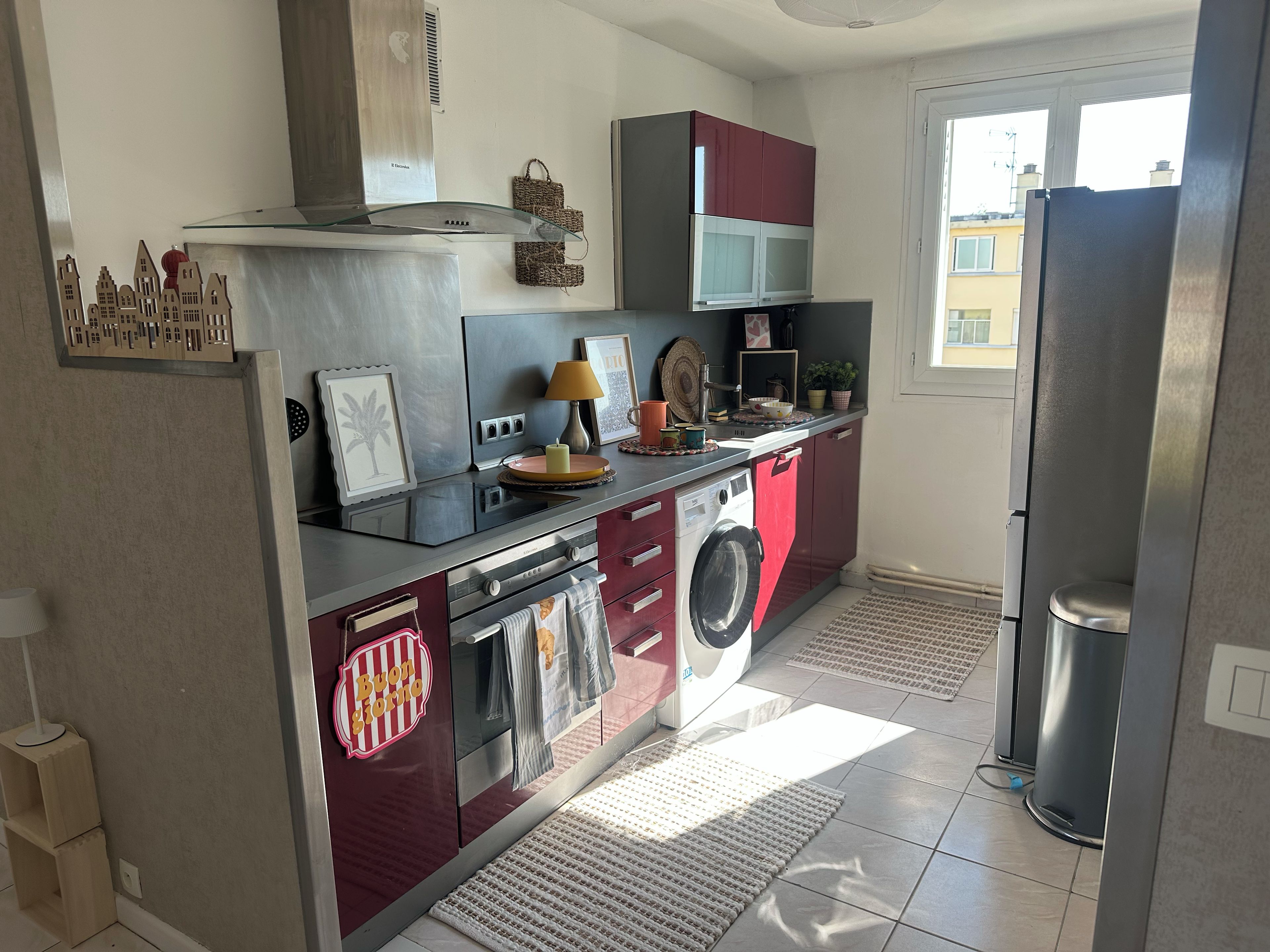 A compact kitchen with a built-in washing machine, a microwave, and a refrigerator.
