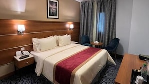 Una camera d'albergo con un letto, comodini, una scrivania e una sedia.