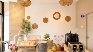 Montaje de desayuno buffet con una tostadora, frascos de conservas y un cartel que dice 'JK Morning Treat'.