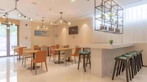 A modern dining area with a bar, multiple tables, and chairs. - City Comfort Inn Xingtai Wanda (Xingtai)