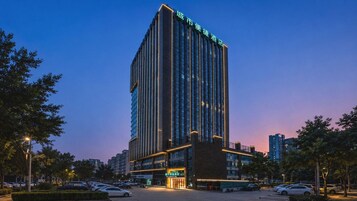 A tall hotel building with a modern design, featuring a prominent entrance and multiple floors.