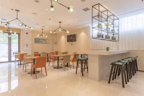 A modern interior with a bar area, seating arrangements, and a decorative hanging shelf. - City Comfort Inn Xingtai Wanda (Xingtai)