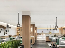 A modern restaurant with a central bar area, multiple dining tables, and pendant lighting.