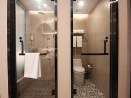 Un baño con cabina de ducha de vidrio, inodoro y lavabo.