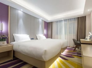 A hotel room with a large bed, a desk, and a chair. - Lavande Hotel (Beijing)