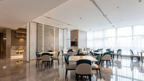 A modern hotel conference room with a polished marble floor, a central table, and several chairs. - Atour Hotel Yiwu International Trade City Passenger Transport Center (Jinhua)