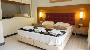 Habitació d'hotel amb llit, taules de nit, un mirall i un quadre al mur.