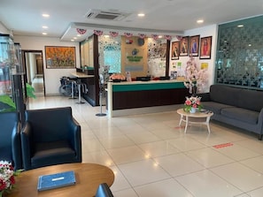 A hotel reception area with a reception desk, a sofa, and a coffee table. - Hotel Desaru Penawar (Bandar Penawar)