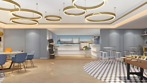 A modern interior with a central bar area, seating arrangements, and a checkered floor pattern. - Magnotel (Harbin)