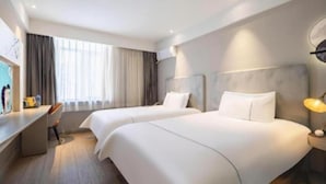 A hotel room with two beds, a desk, and a chair. - Magnotel (Harbin)