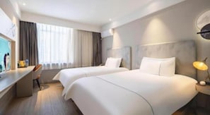 Una habitación de hotel con dos camas, un escritorio y una silla.
