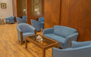 A room with a wooden floor, a glass coffee table, and blue armchairs. - Grand Al Massa Hotel (Makkah)