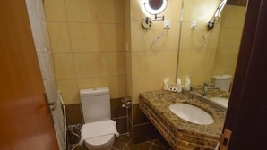 Un baño con inodoro, lavabo y espejo.
