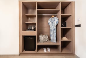Un vestidor con barra para colgar, estantes y un electrodoméstico pequeño.