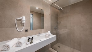 A modern bathroom with a glass shower enclosure, a white sink, and a mirror above it. - Ixia Dream - Adults Only (Rhodes)
