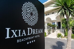 A sign for the Ixia Dream Beachfront Hotel with a logo and name. - Ixia Dream - Adults Only (Rhodes)