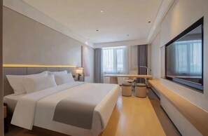 A modern hotel room with a large bed, a desk, and a television. - Thank (Changsha)