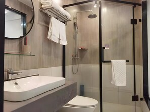 A modern bathroom with a glass-enclosed shower, a white sink, and a toilet. - Thank (Changsha)