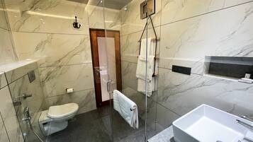 Une salle de bain moderne équipée de toilettes, d’une douche et d’une baignoire.