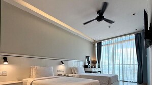 Una habitación de hotel moderna con una cama grande, mesitas de noche, un escritorio y un ventilador de techo.
