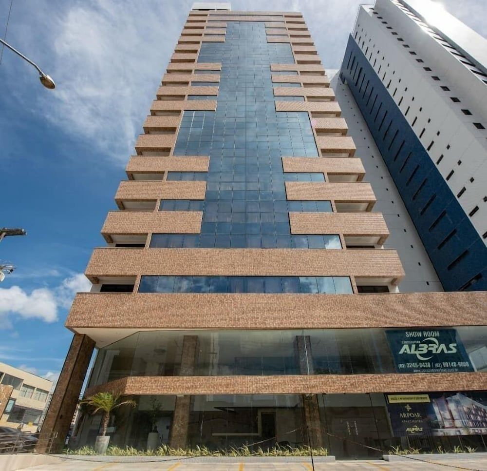 Um edifício moderno com fachada de vidro, vários andares e uma placa para uma sala de exposição.