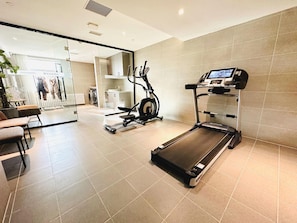 A gym with a treadmill, exercise bike, and a mirrored wall. - Homeinns Plus Longhua Road Qiqihar (Qiqihar)