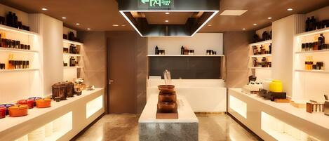 A modern interior with a central island, shelves on both sides, and a ceiling sign indicating an exit.