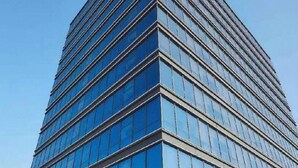 Un hôtel moderne doté d’une façade en verre et d’une signalétique en anglais et en chinois.
