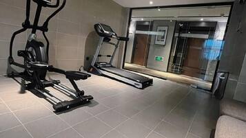 A gym with exercise equipment including a treadmill and an elliptical machine.