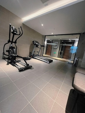 A gym with exercise equipment including a treadmill and an elliptical machine.