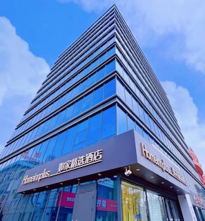 Hotel modern amb façana de vidre i indicadors de 'Homeplus' i 'Homeplus Hotel'.
