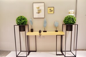 A reception desk with a number sign indicating room 509, flanked by two potted plants and decorative leaves. - Homeinn Selected (Guangzhou)