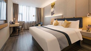 A hotel room with a large bed, a desk, and a chair. - Homeinn Selected (Guangzhou)
