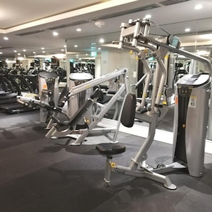 Un gimnasio con varias máquinas de ejercicio, incluyendo una prensa de piernas y una prensa de pecho.