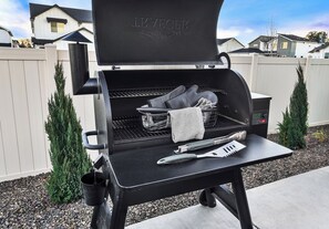 A black outdoor grill with a digital display, a side table, and a pair of tongs. - Sleeps 16 | Hot Tub +Game Garage + Kids' Play Loft (Meridian)
