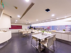 Ein modernes Restaurant mit einer zentralen Theke, mehreren Sitzbereichen und einer dekorativen Fliesenwand.